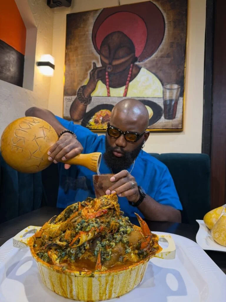 Opeyemi Famakin pouring palm wine into a cup